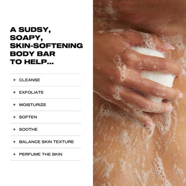 Hand holding a sudsy body bar with text listing benefits on a white background