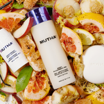 Dynamic image of the Dirty Citrus Bath Bundle laid down on top of citrus, leaves, and dirt