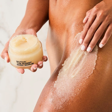 Model applying MUTHA Body Scrub to leg