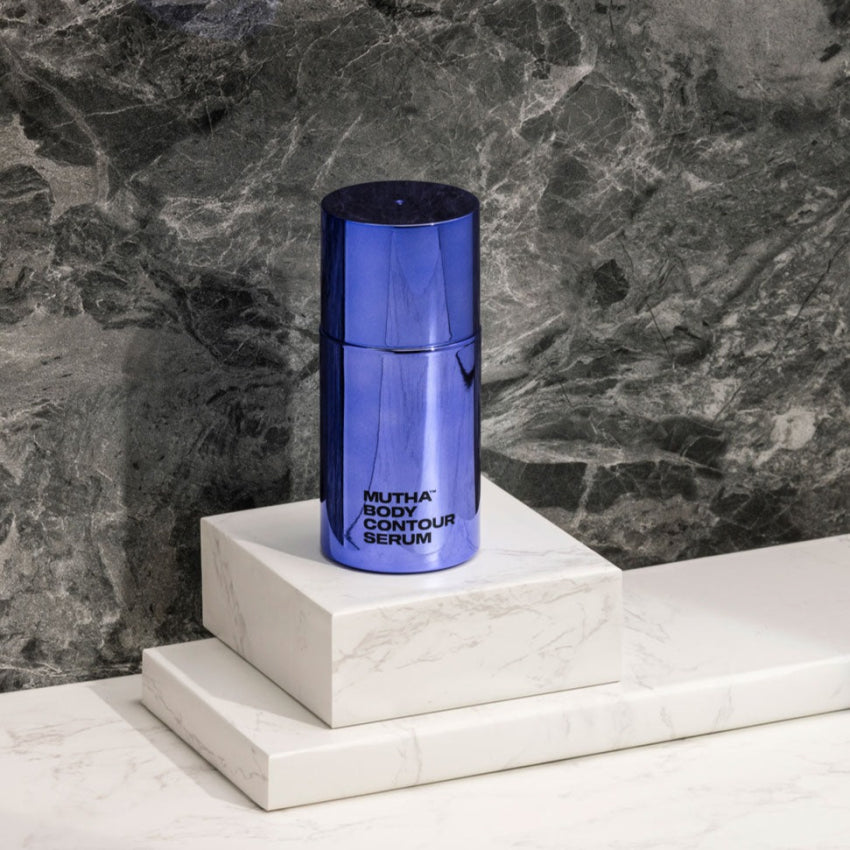 Image of the Body Contour Serum standing on marble blocks against a marble background