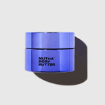 Purple-blue jar of 'Mutha Body Butter' on a light gray background