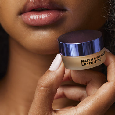 Close-up image of a model holding the MUTHA Pucker Lip Butter near the lips