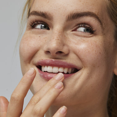 Model applying the MUTHA Pucker Lip Butter with a finger