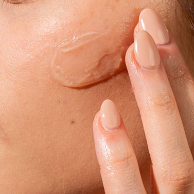 Hand applying a skincare product to skin